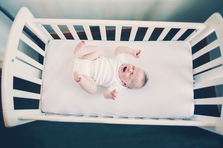 Crying baby in a crib
