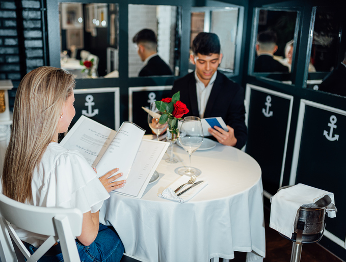 Young man and woman read the menu in a fancy restaurant.