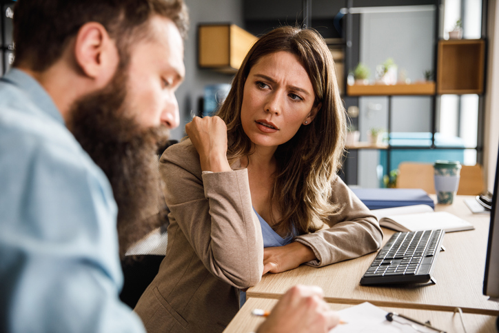Annoyed businesswoman discussing project data and ideas with a male colleague