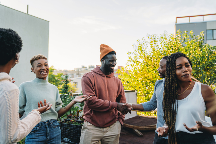 Group of friends gathering on a rooftop, people are introducing themselves to each other