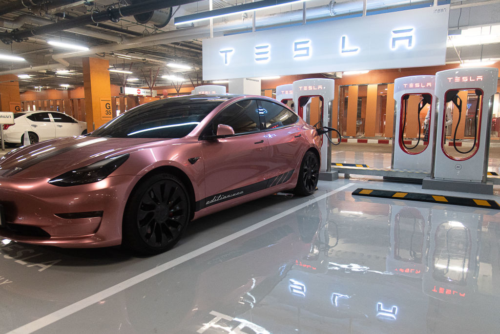 A Tesla car seen charging at the Tesla supercharger station...