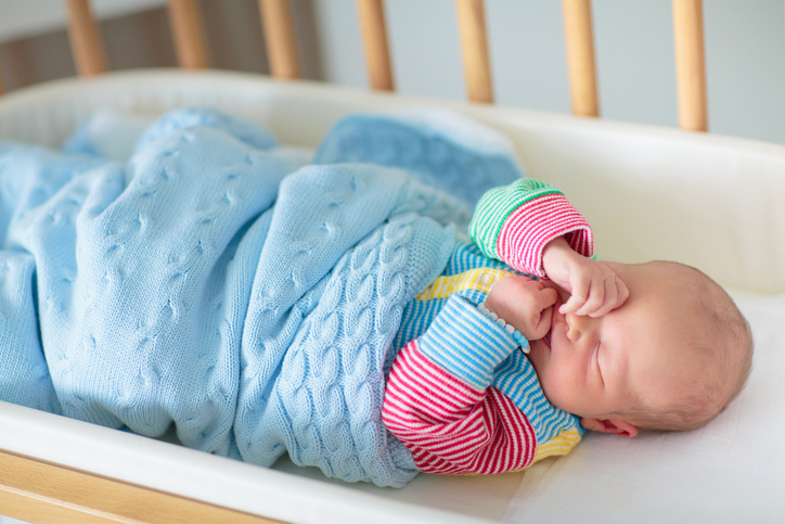 Newborn baby boy in hospital cot