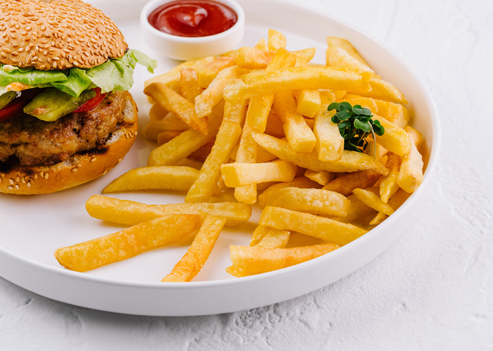 Classic burger and fries on white plate with ketchup