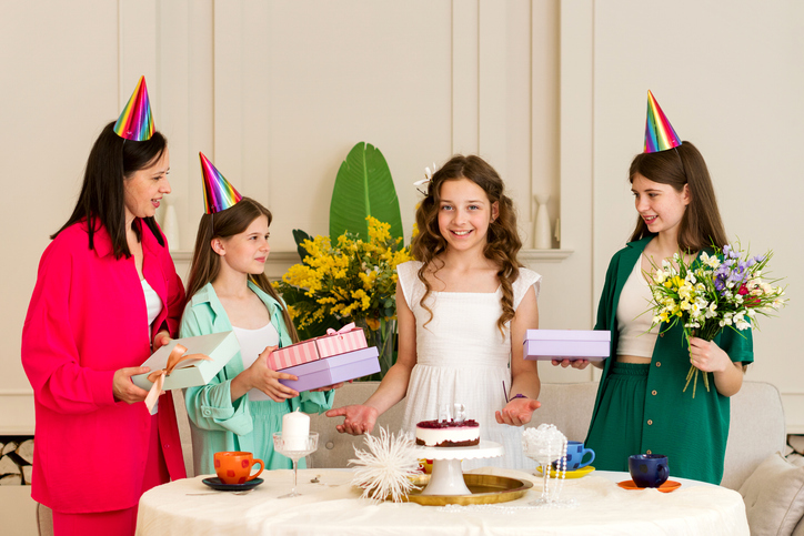 Girl in white dress is surrounded family and friends