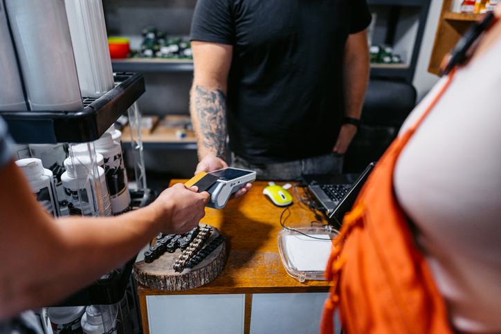 Young Couple Paying Via Credit Card In A Moto Shop