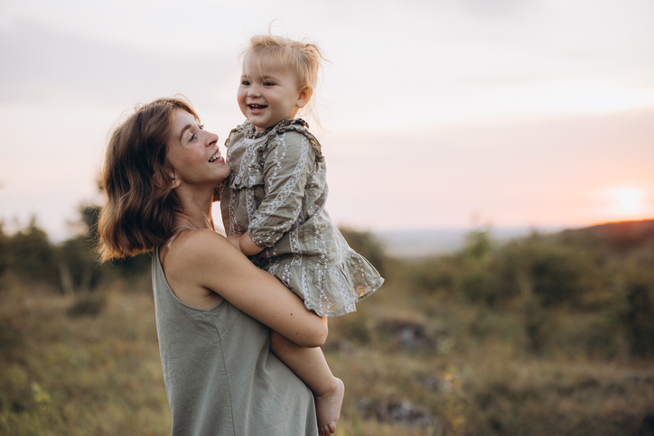 Mother and Daughter Enjoying a Beautiful Sunset in the Outdoors, Sharing a Joyful Moment of Bonding and Happiness