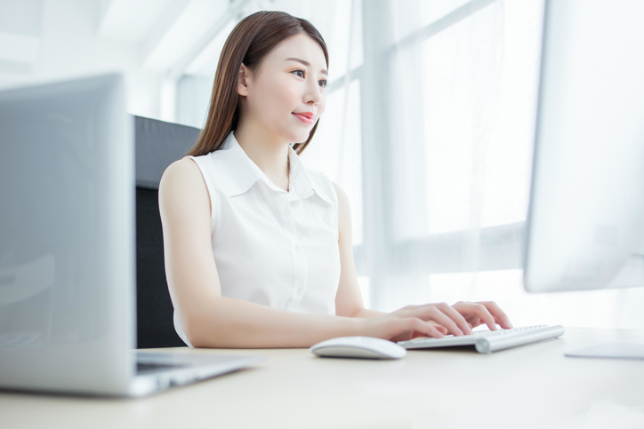 Confident businesswoman working on computer in modern office