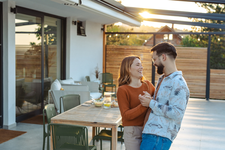 Romantic couple embracing on modern outdoor patio at sunset