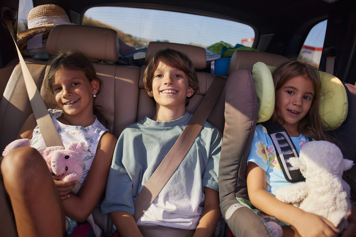 Brother and sisters enjoying traveling by car