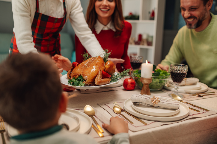 Family enjoying christmas or thanksgiving dinner with roasted turkey