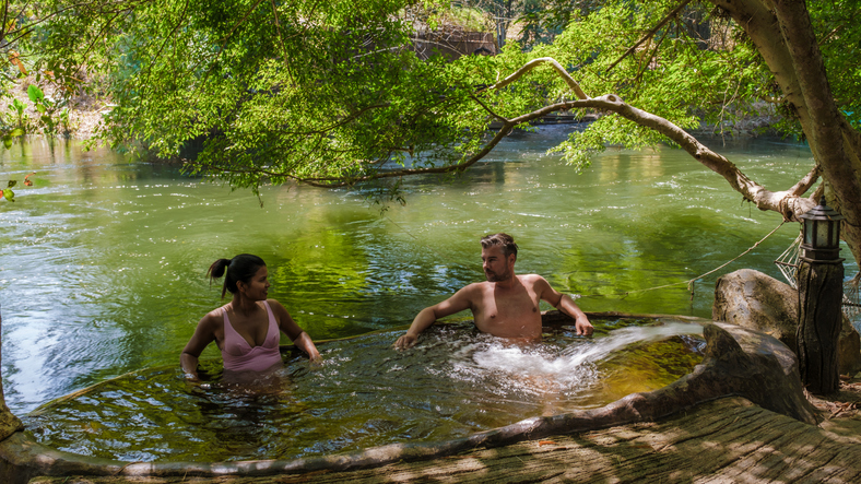 Relaxing in natural pool by the river in Bali, Thailand on a sunny day