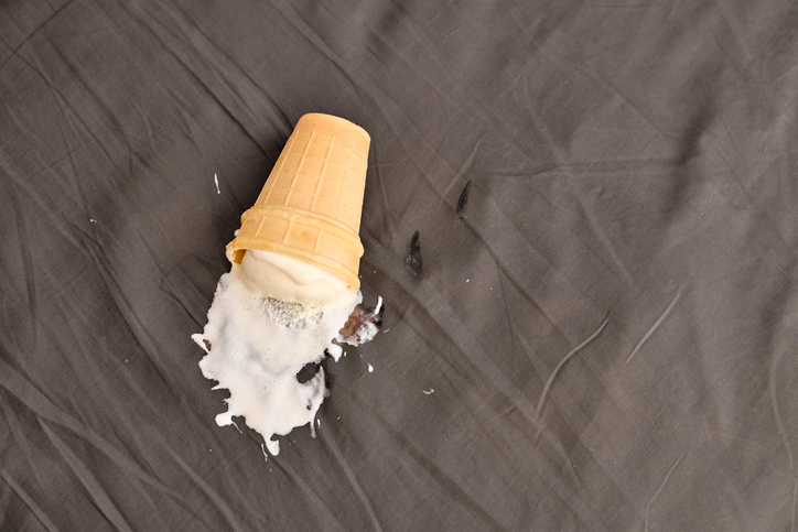 Ice cream cone accident on dark fabric surface