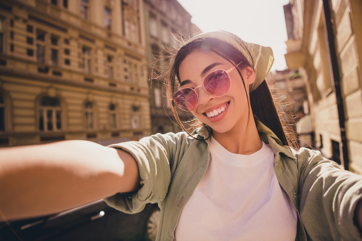 Photo of positive lovely girl toothy smile make selfie recording video spend pastime city center outside