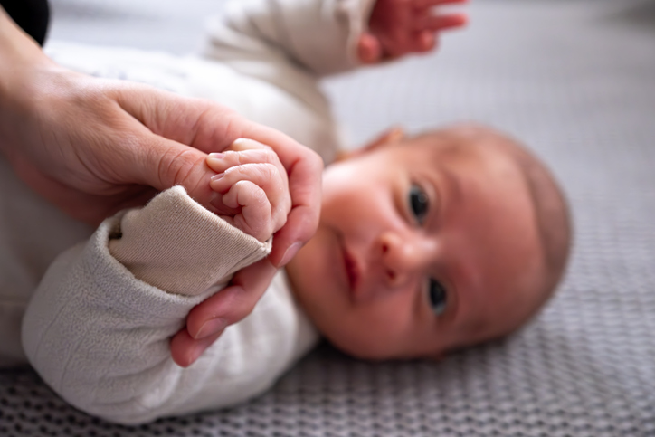 Close-Up of a Baby Holding an Adult's Hand in Emotional Connection