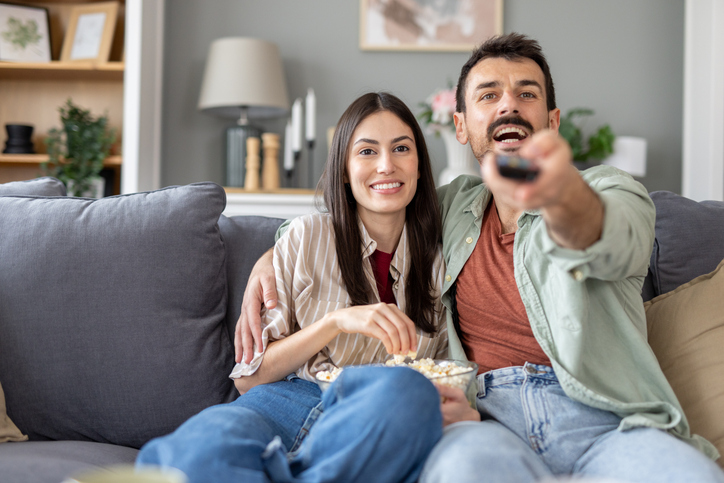 Couple enjoying a casual movie night with popcorn.