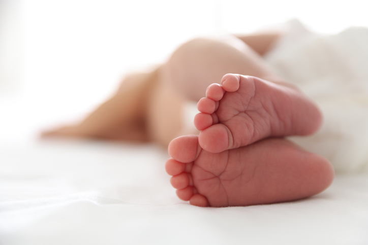 Cute newborn baby lying on bed, closeup. Space for text