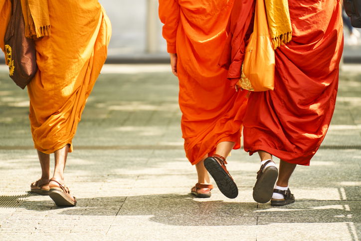 Buddhist monks walking in saffron robes on urban street