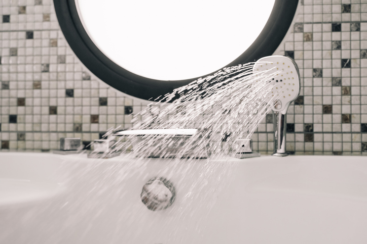 Water pouring from the shower. Circle window on a background.
