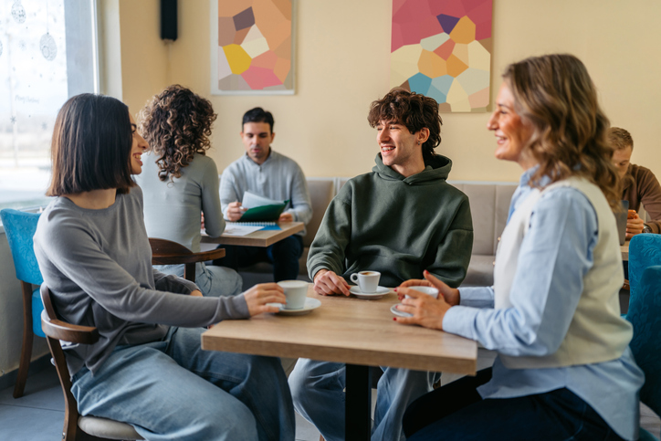 Group Of Three Friends Drinking Coffee In A Café